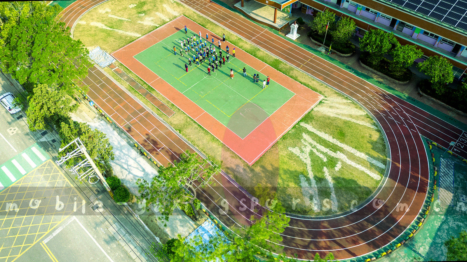 高原暮色笼罩下的球场全景，看台灯光与半透明数据网格叠在一起